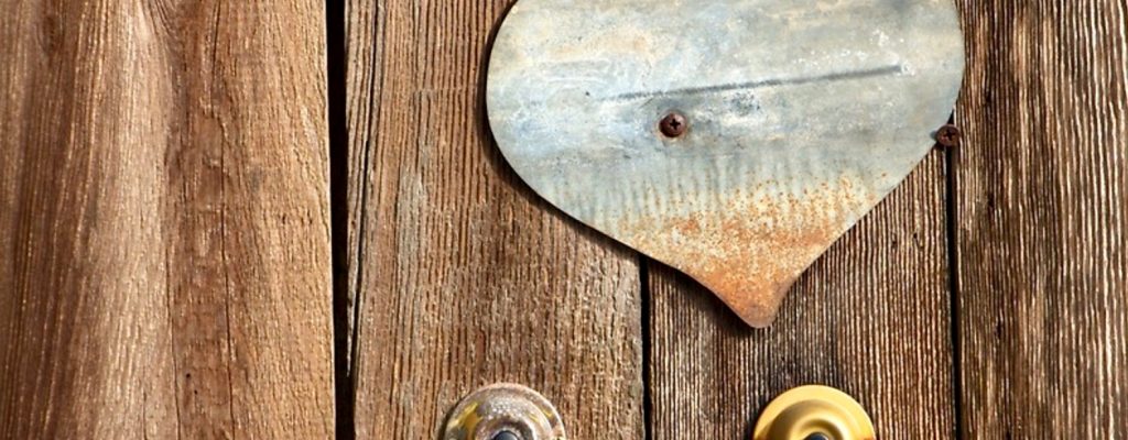Doorbells and Metal Heart on Wooden Fence